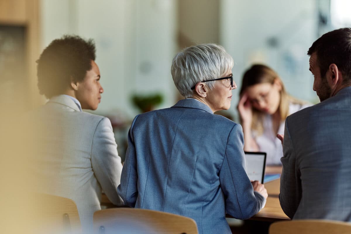 Employees working together at a shared conference table.