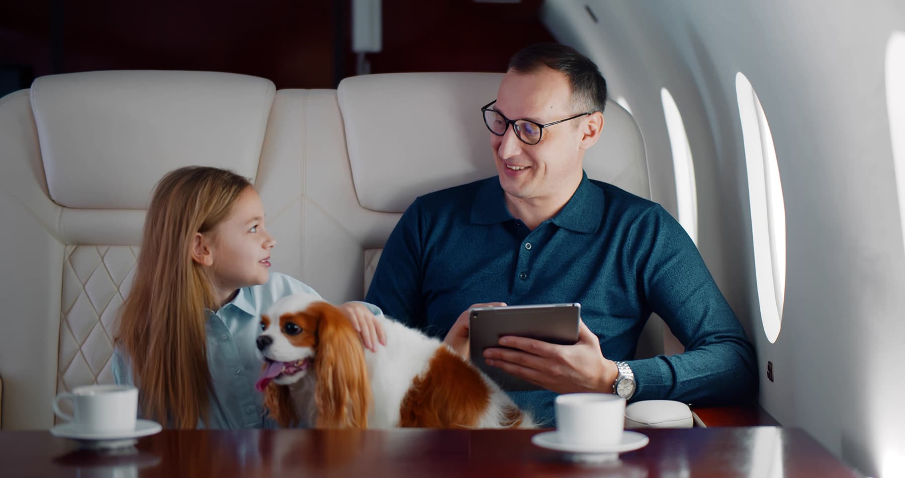 Father and child with dog on private jet